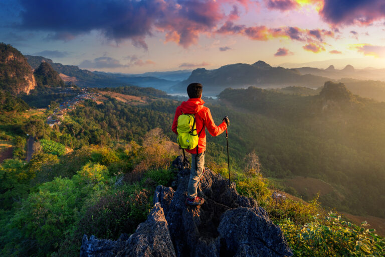 Backpacker standing on sunrise viewpoint at Ja Bo village, Mae hong son province, Thailand.