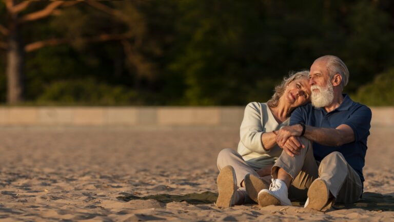 full-shot-couple-sitting-sand