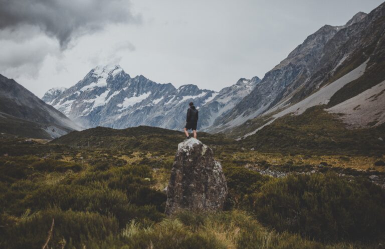 man standing stone hooker valley track with view mount cook new zealand